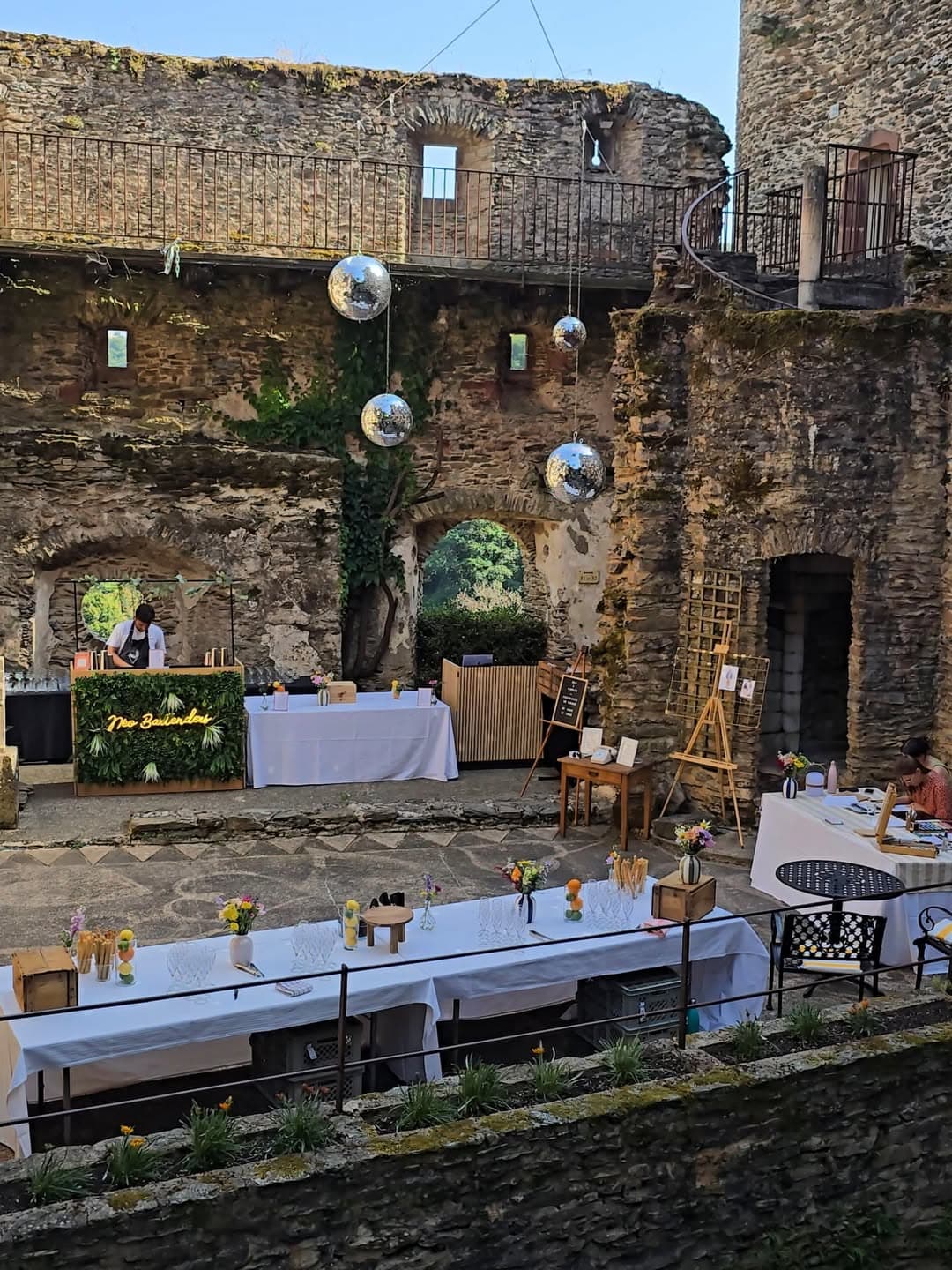 Le bar Néo Bartenders et son enseigne néon installés dans la cour d'un château pour un évènement